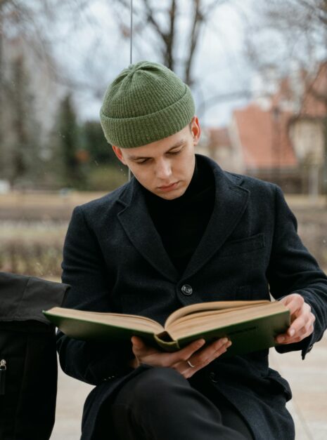 Photo by MART PRODUCTION A Man in Black Coat Reading a Book